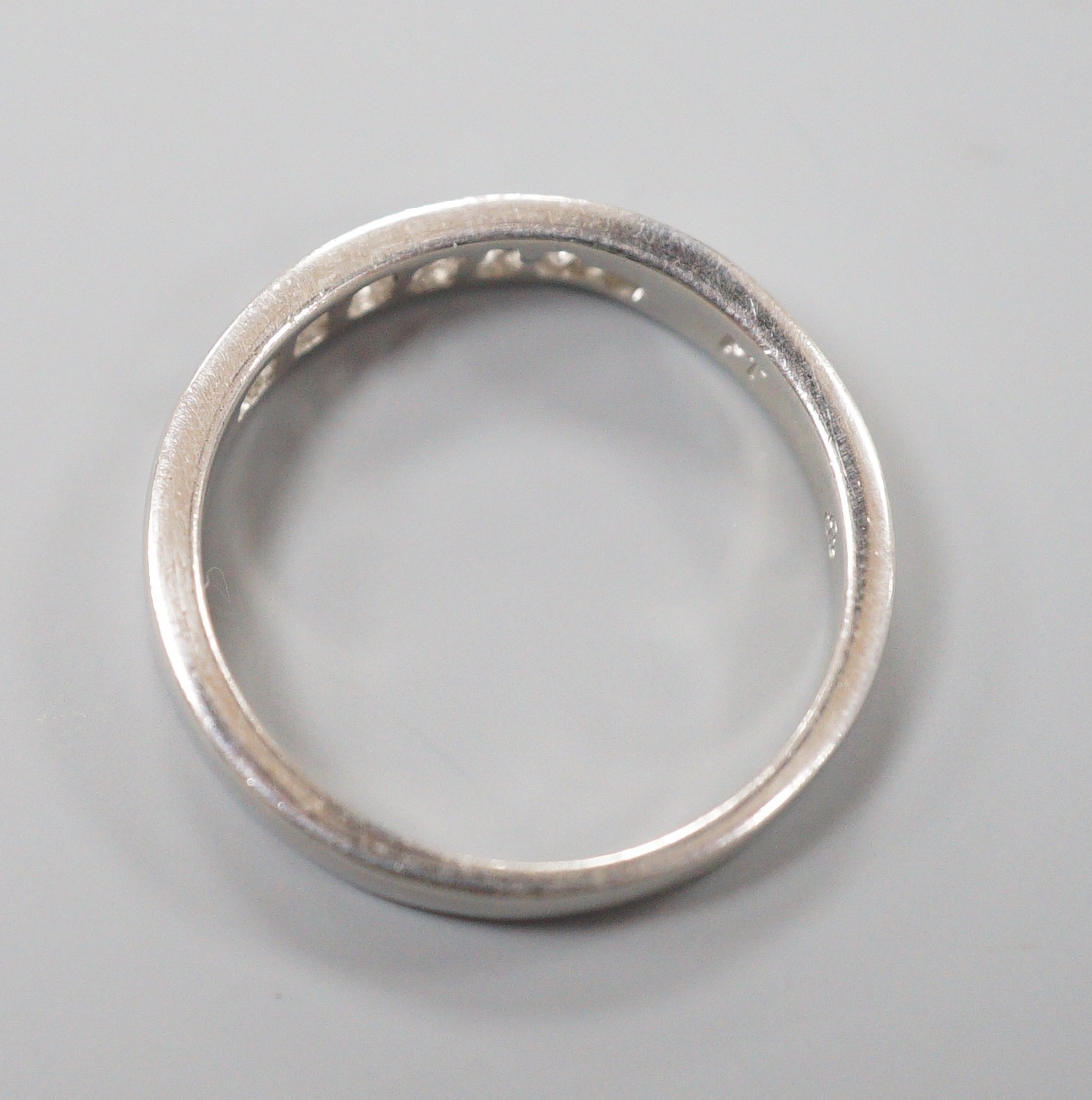 A modern platinum and channel set seven stone half hoop ring, size P, gross weight 5.1 grams